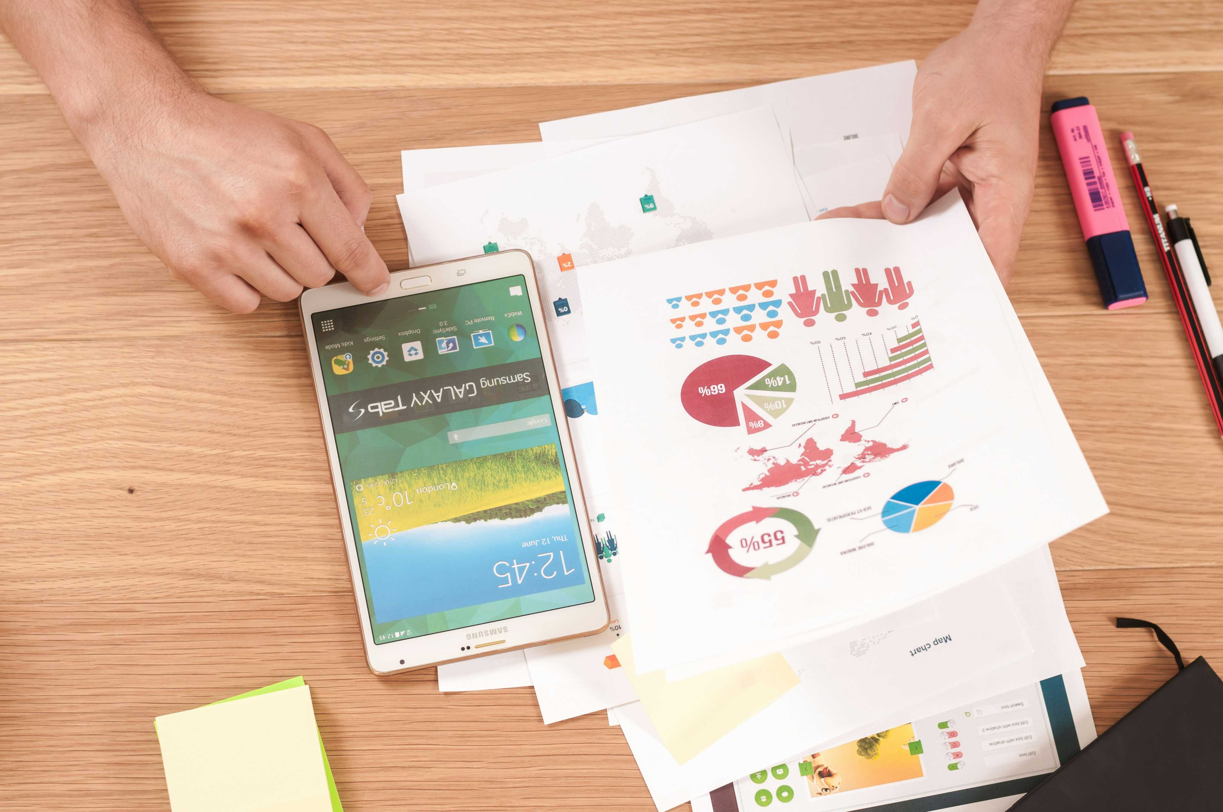 Pessoas analisando gráficos em uma mesa de trabalho