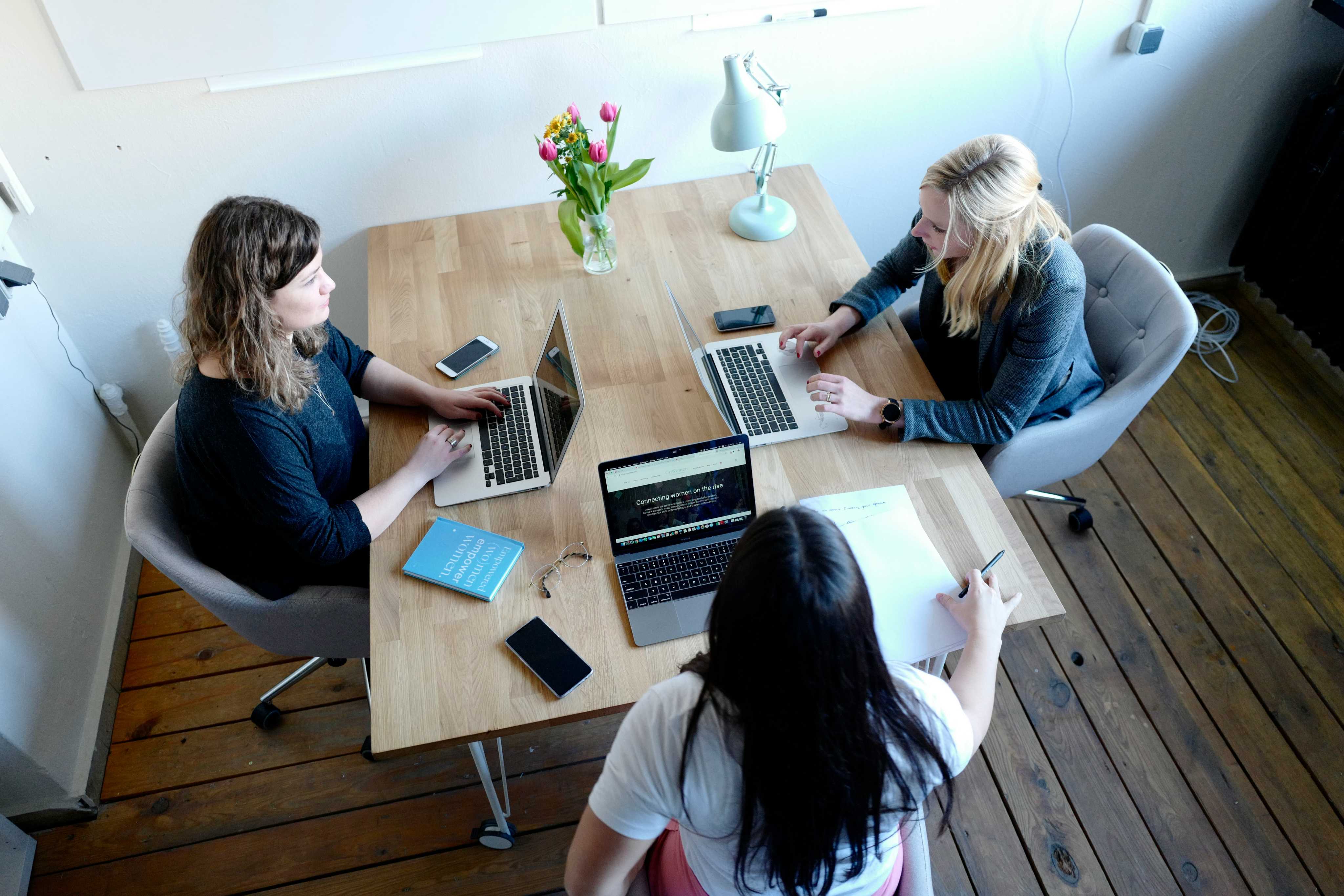 Mulheres conversando em uma mesa de coworking