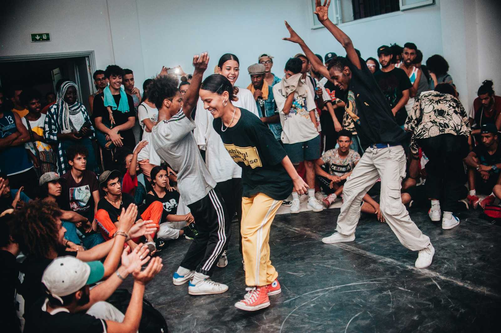 Jovens reunidos em roda assistindo a uma apresentação de dança